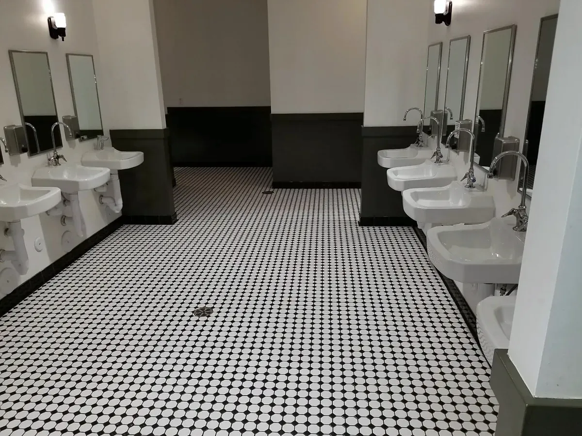 Commercial restroom with a row of sinks and a patterned floor